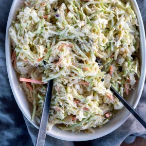 bowl of coleslaw with serving spoons.