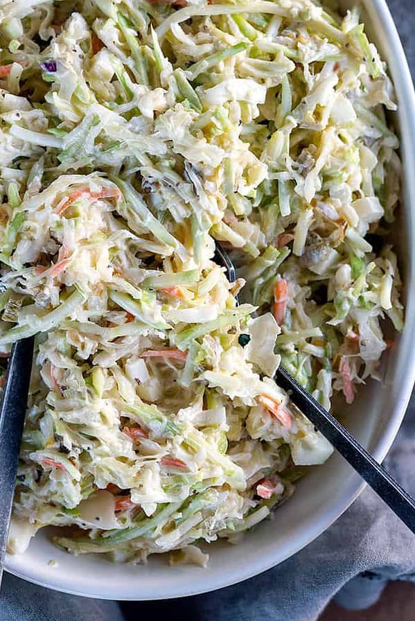 bowl of coleslaw with serving spoons.