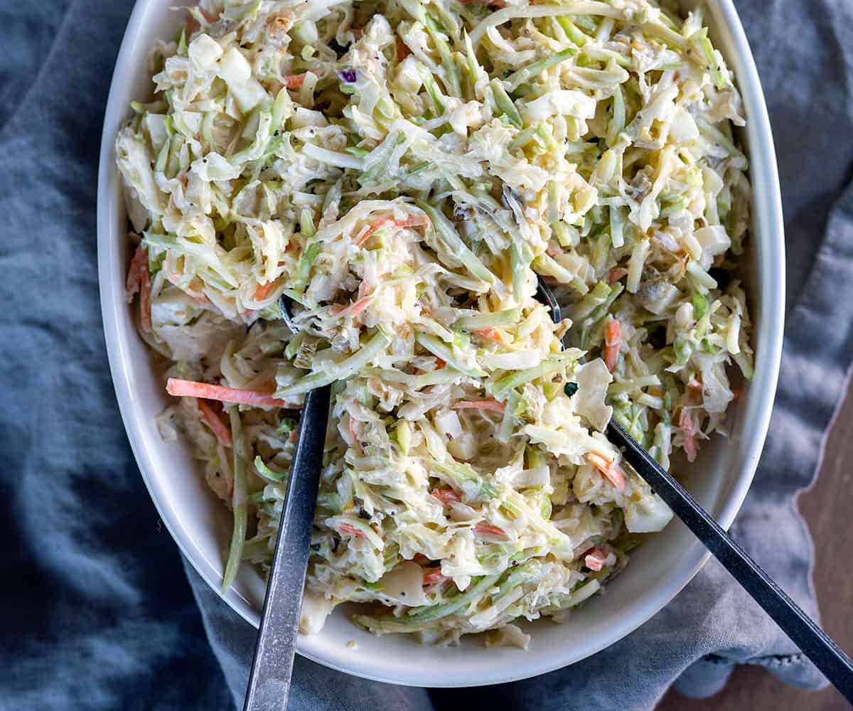 bowl of coleslaw with serving spoons. 