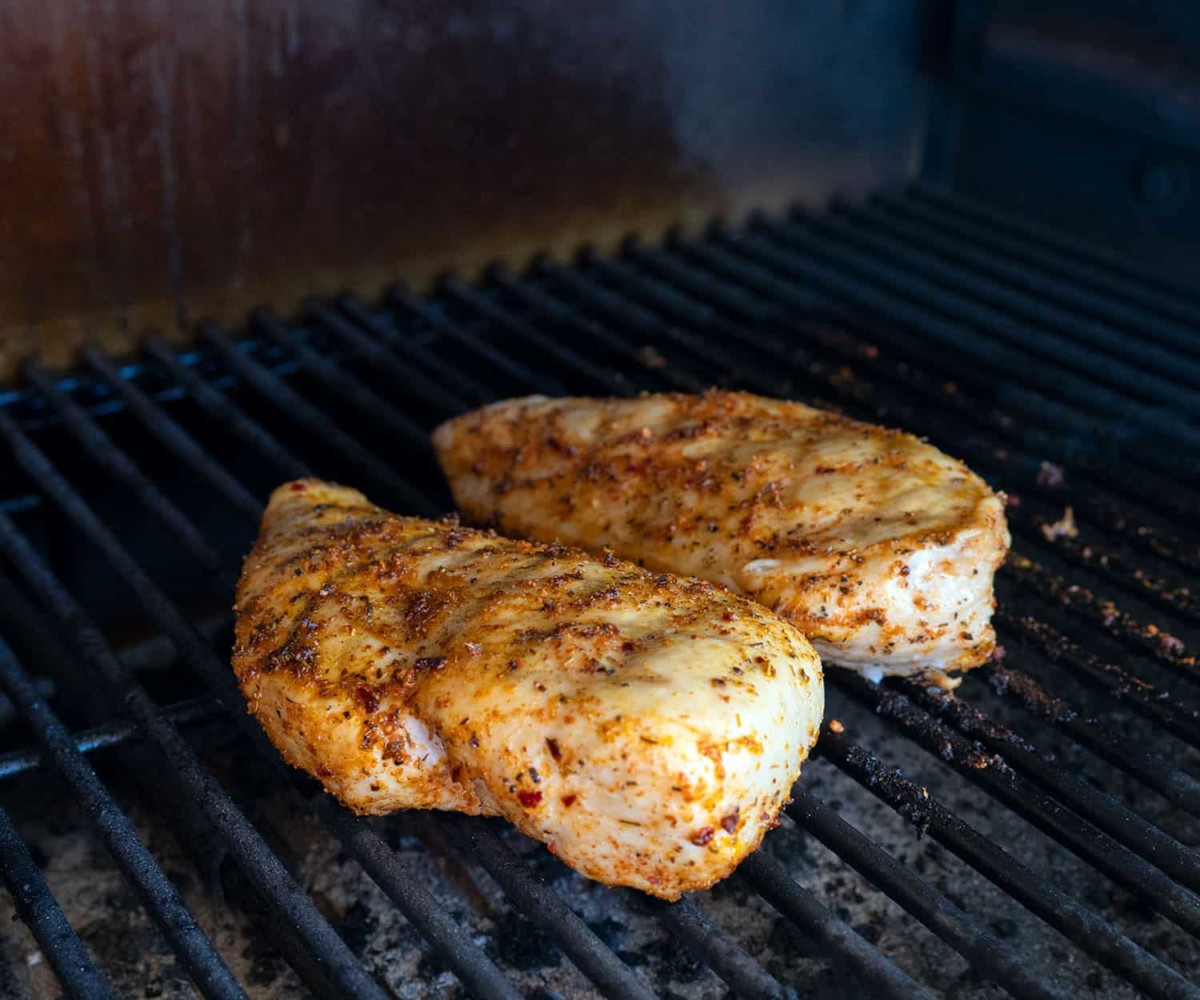 two chicken breasts on a pellet grill.