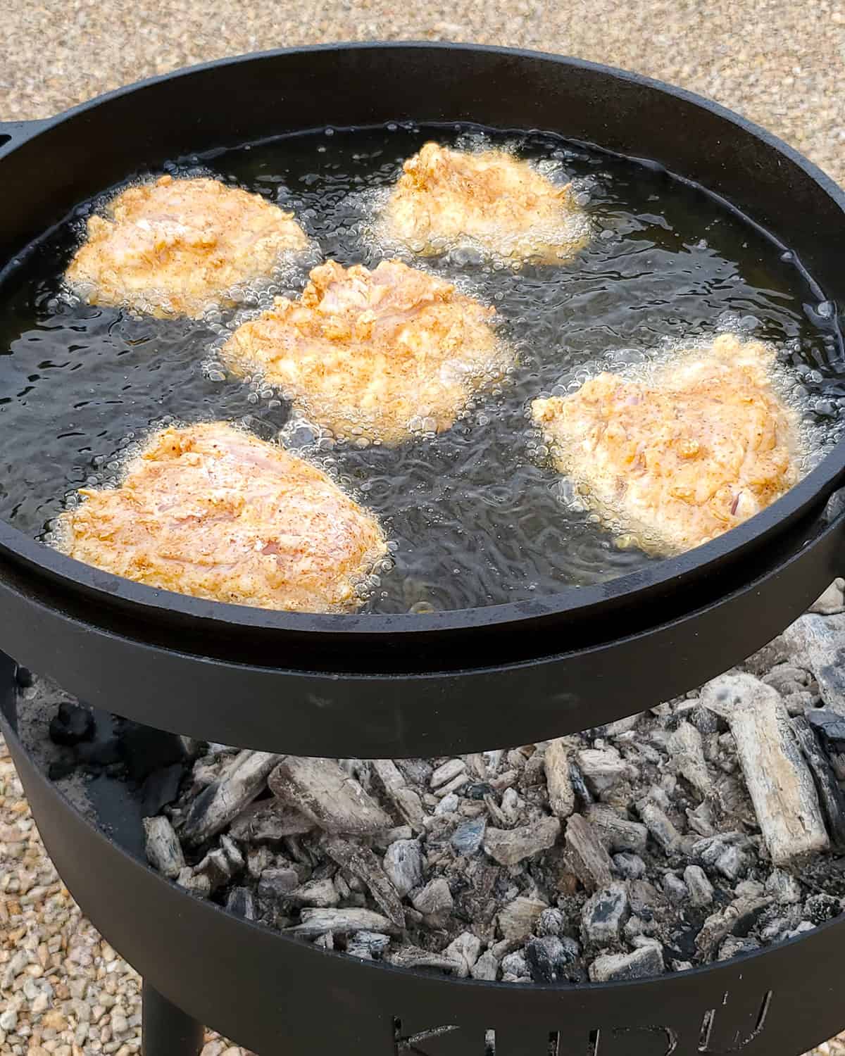 Nashville hot chicken frying in skillet.