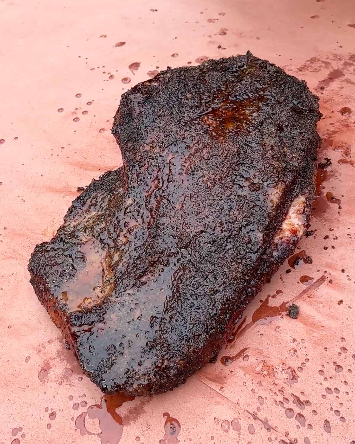 Smoked brisket on butcher paper spritzed with vinegar and tallow.
