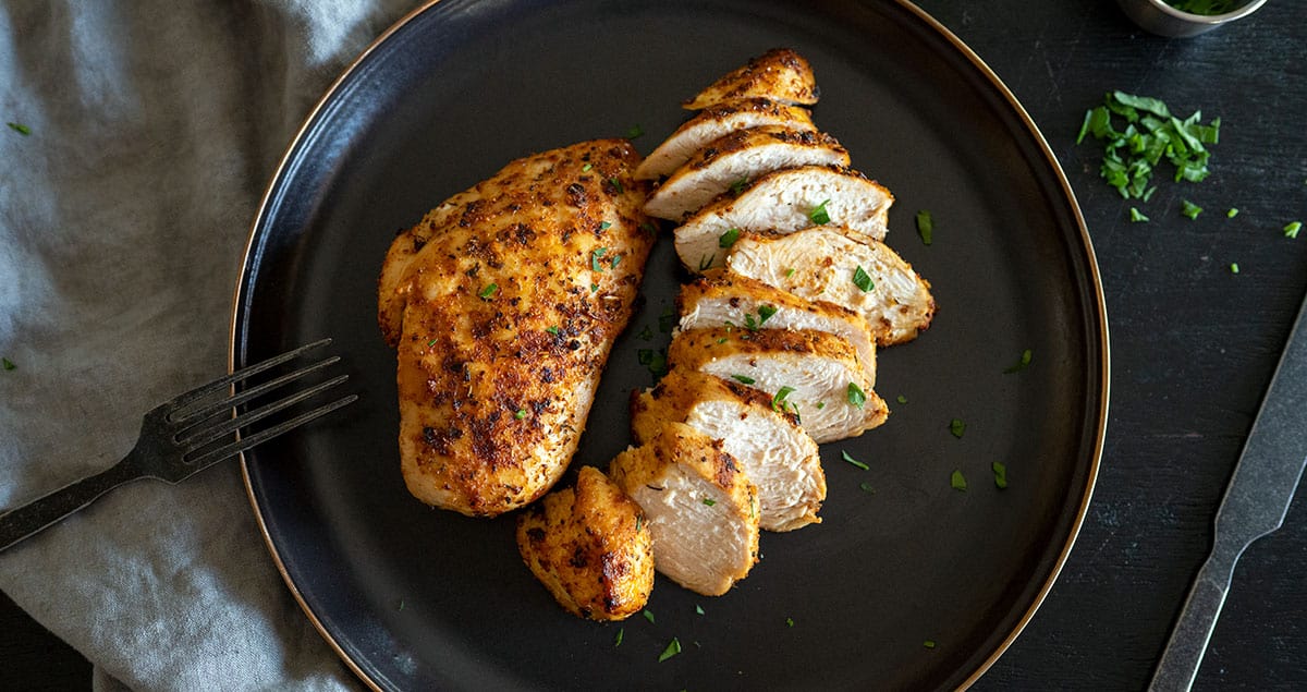 sliced grilled chicken breast on plate.