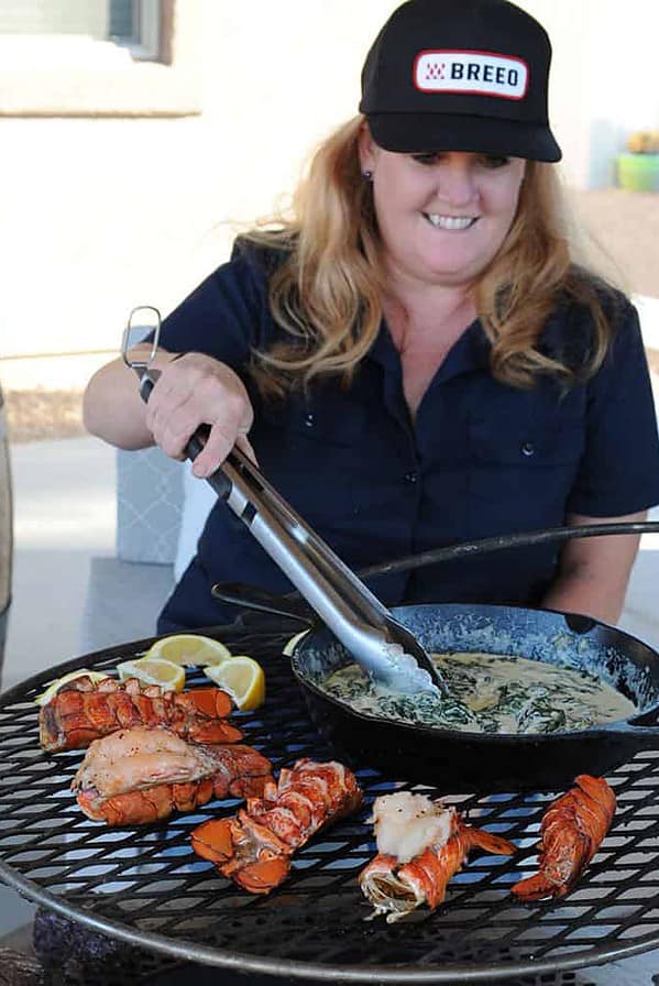 woman grilling lobster and creamed spinach