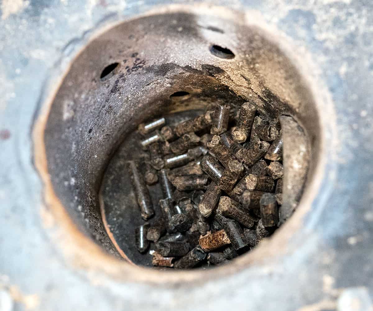 Wood pellets loading into a fire pot.
