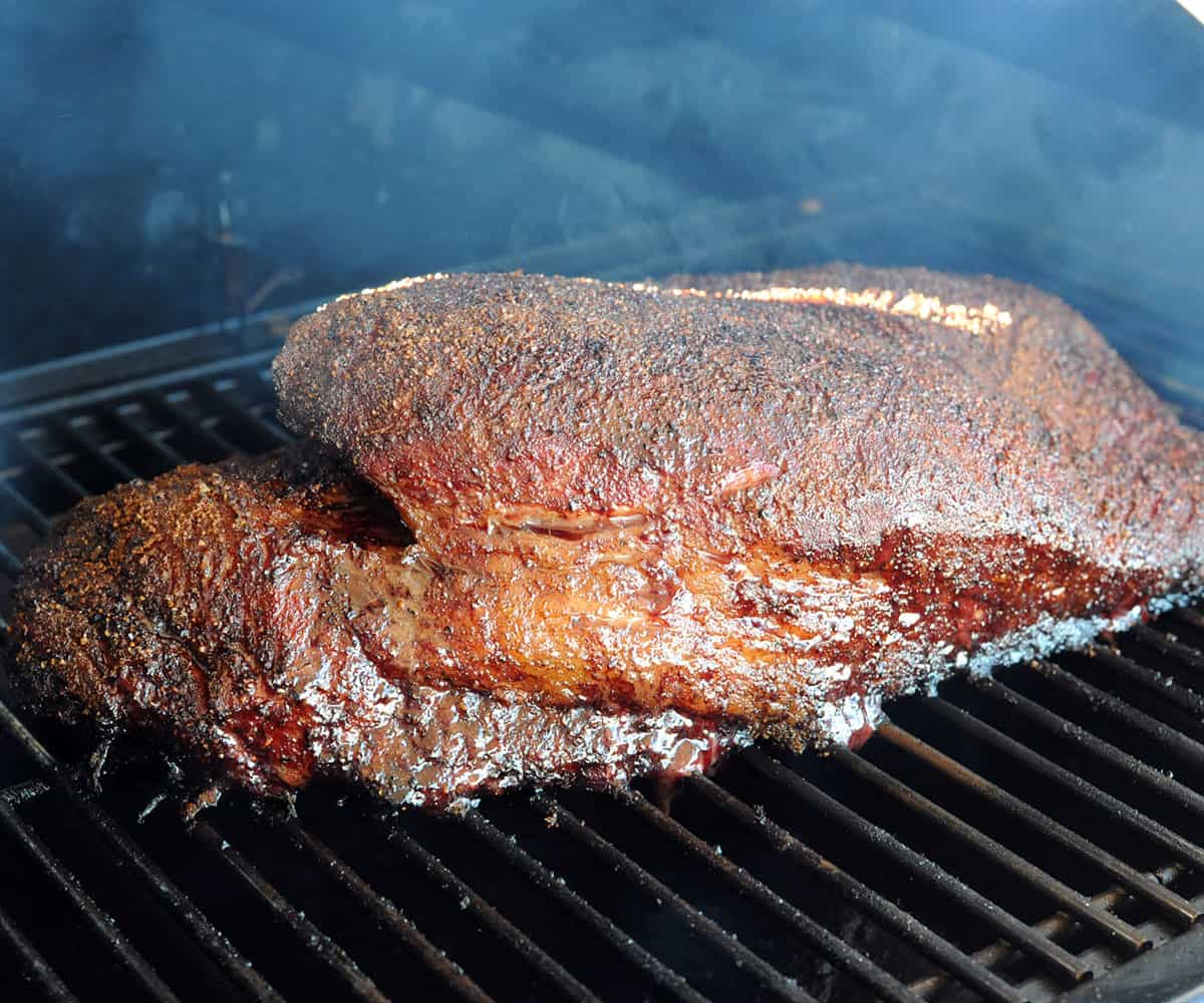 smoked brisket on pellet grill with thick bark.