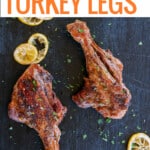 grilled butterflied turkey legs on platter with lemons.