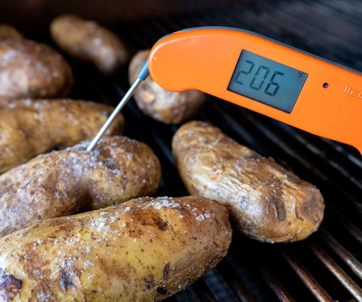thermometer showing temperature inside potato is 206 degrees.