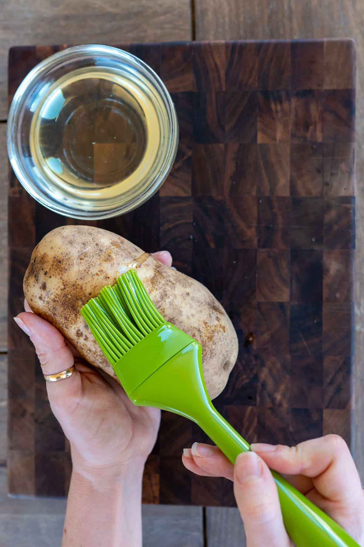 brushing oil on potato.