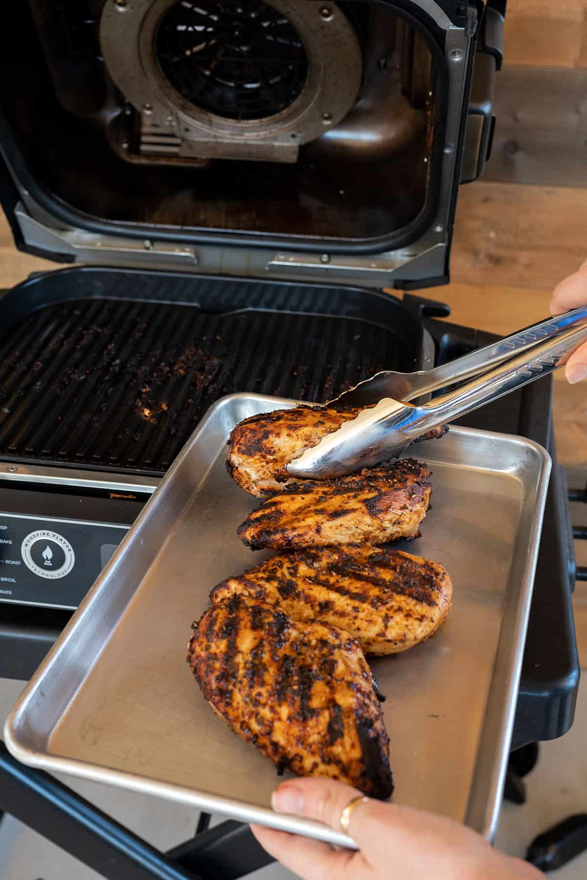 taking chicken breasts off the grill.