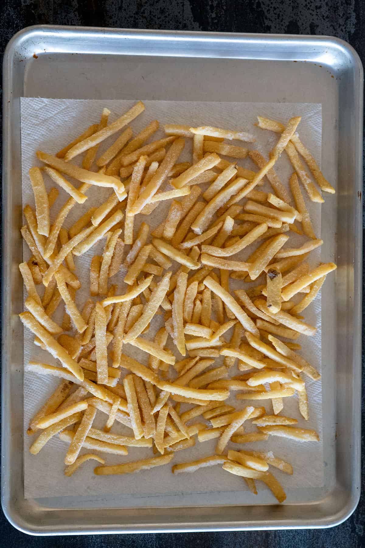 frozen fries thawing on sheet pan.