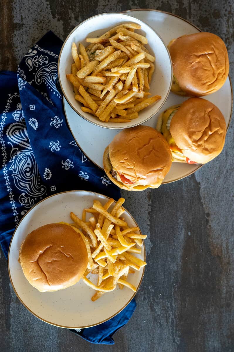 overhead photo of four hamburgers with fries.