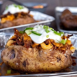 Loaded baked potato on table in pan.
