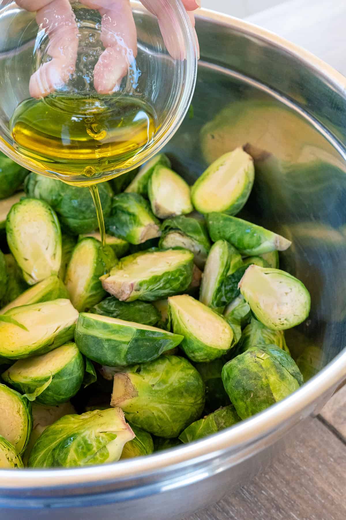 pouring olive on halved brussels sprouts.