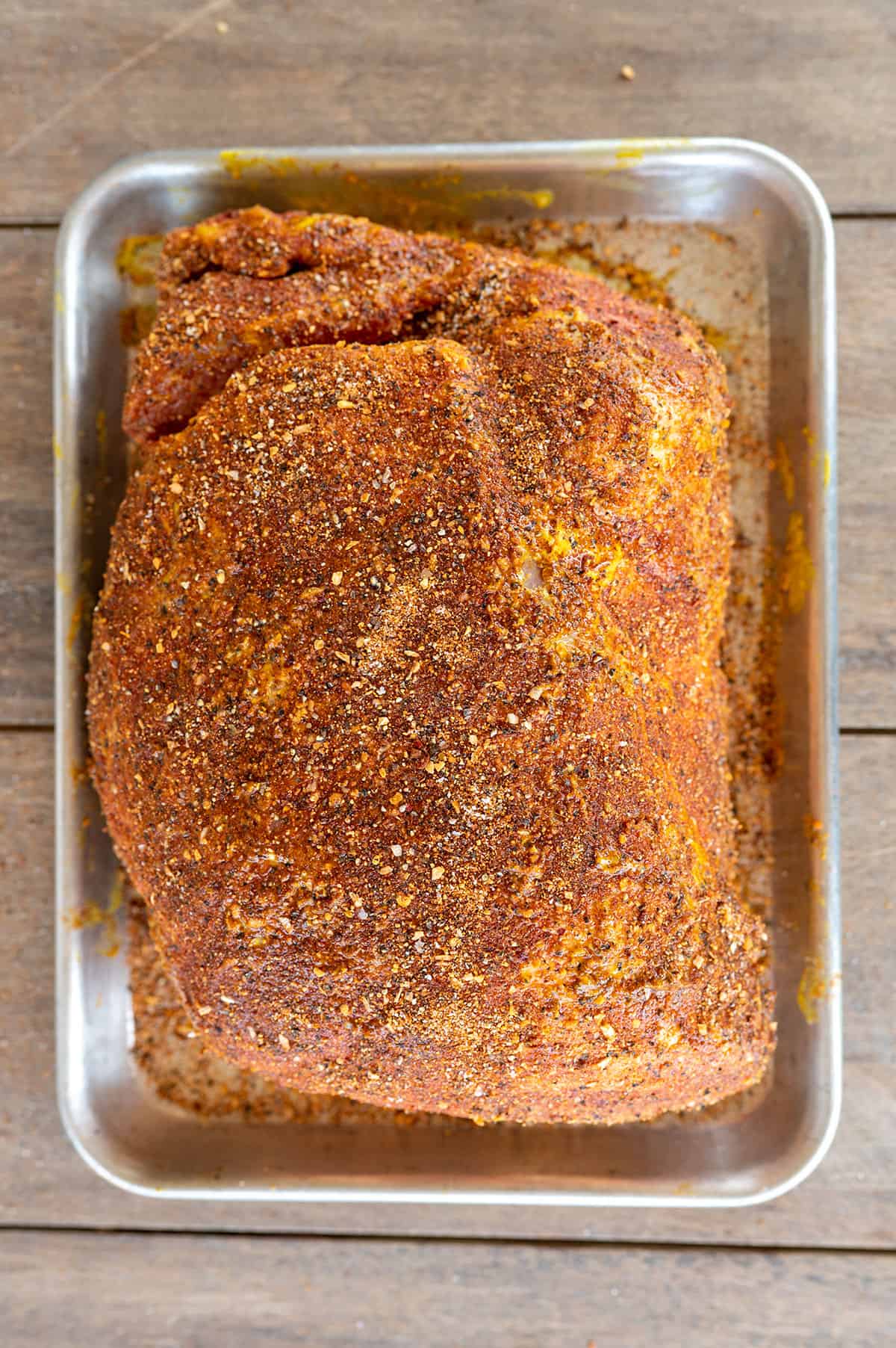 pork shoulder seasoned and resting on pan.