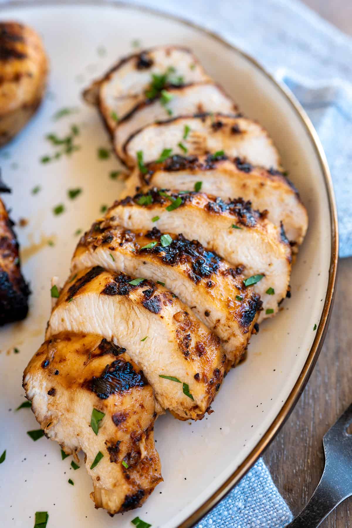 sliced grilled chicken breast on white plate