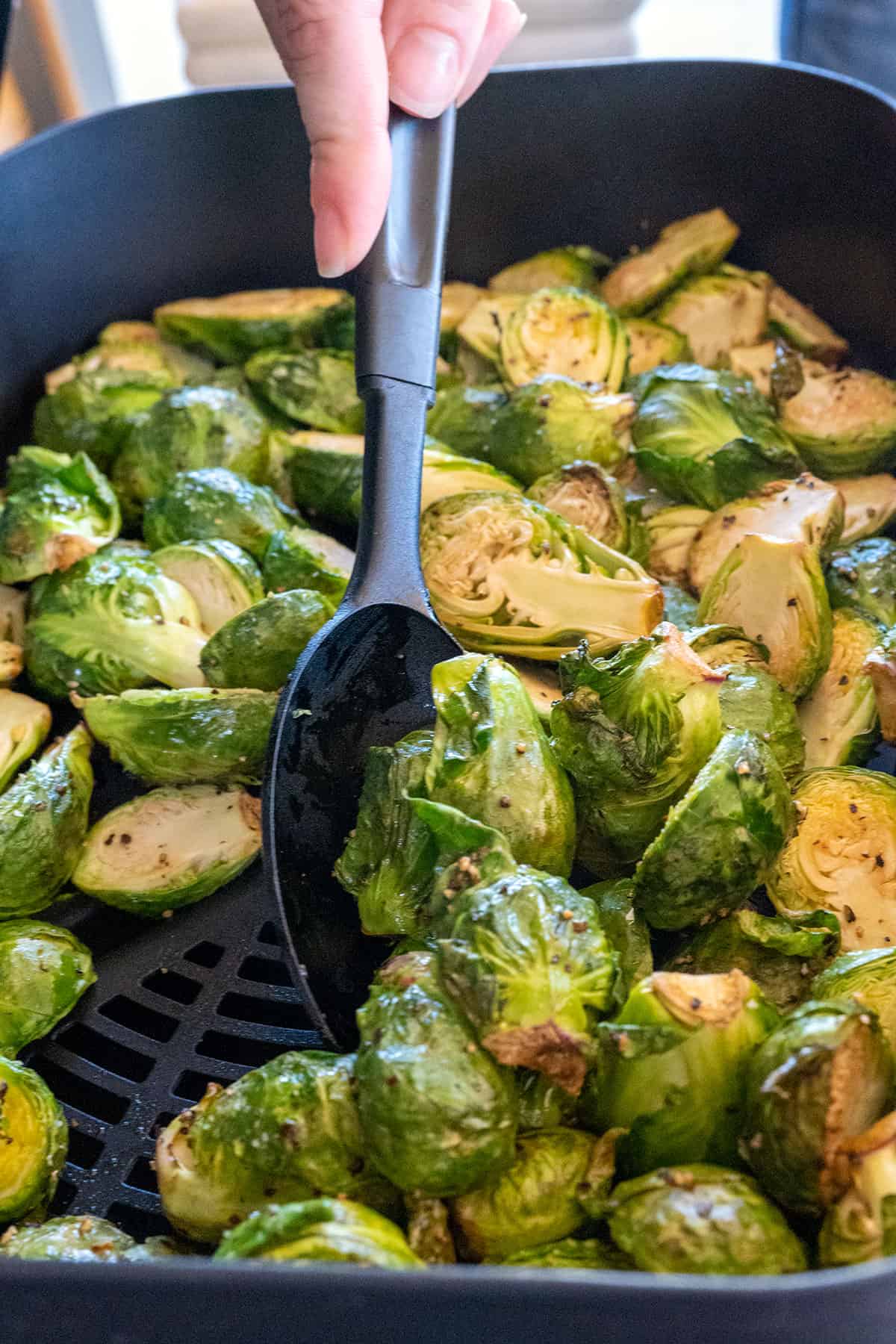 stirring sprouts in grill.