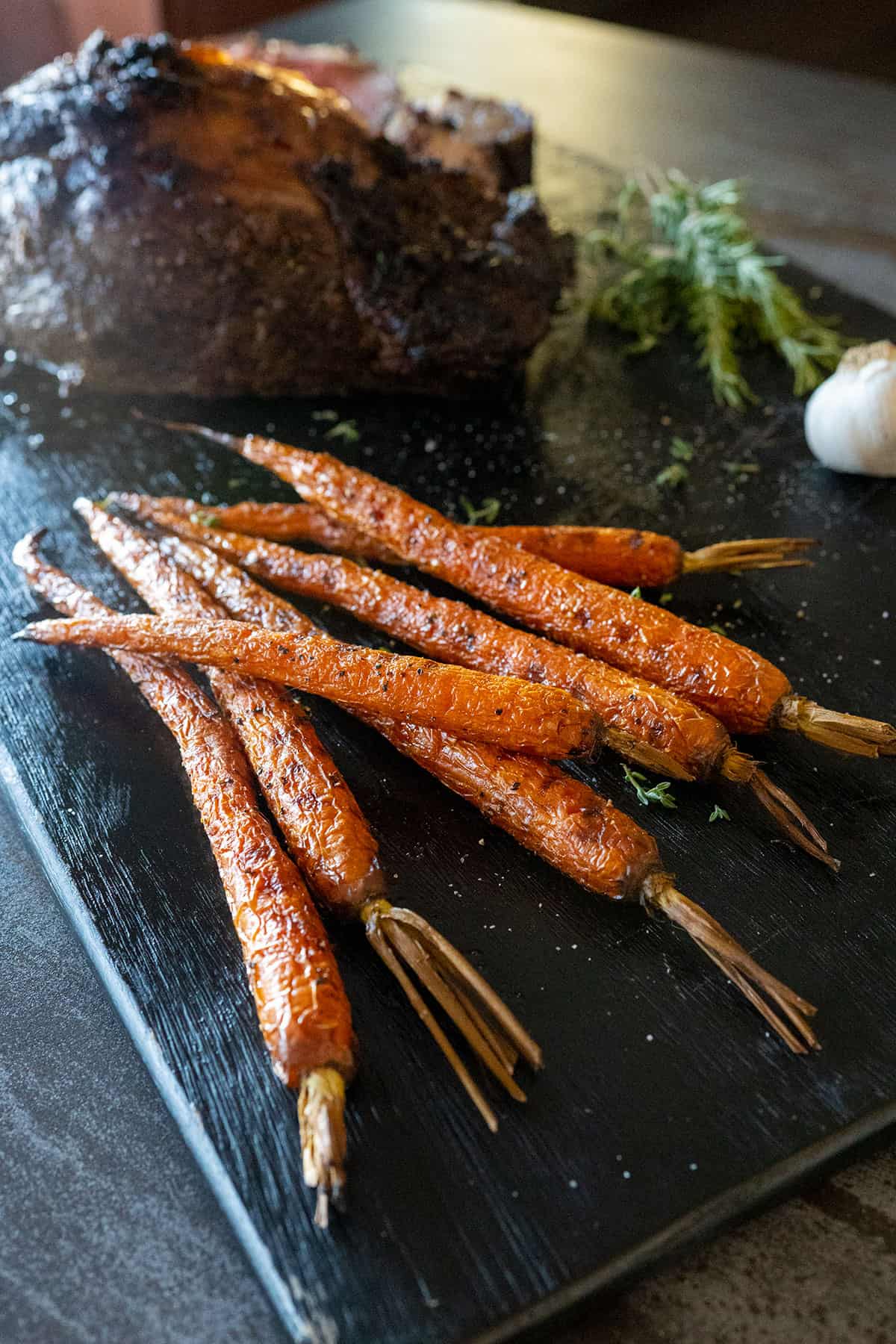 grilled carrots on black board.