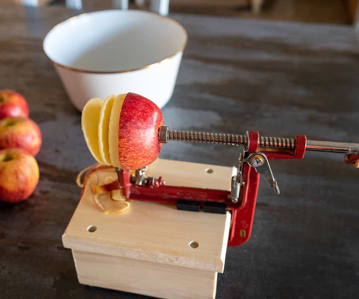 apple going through apple peeler, corer, slicer.