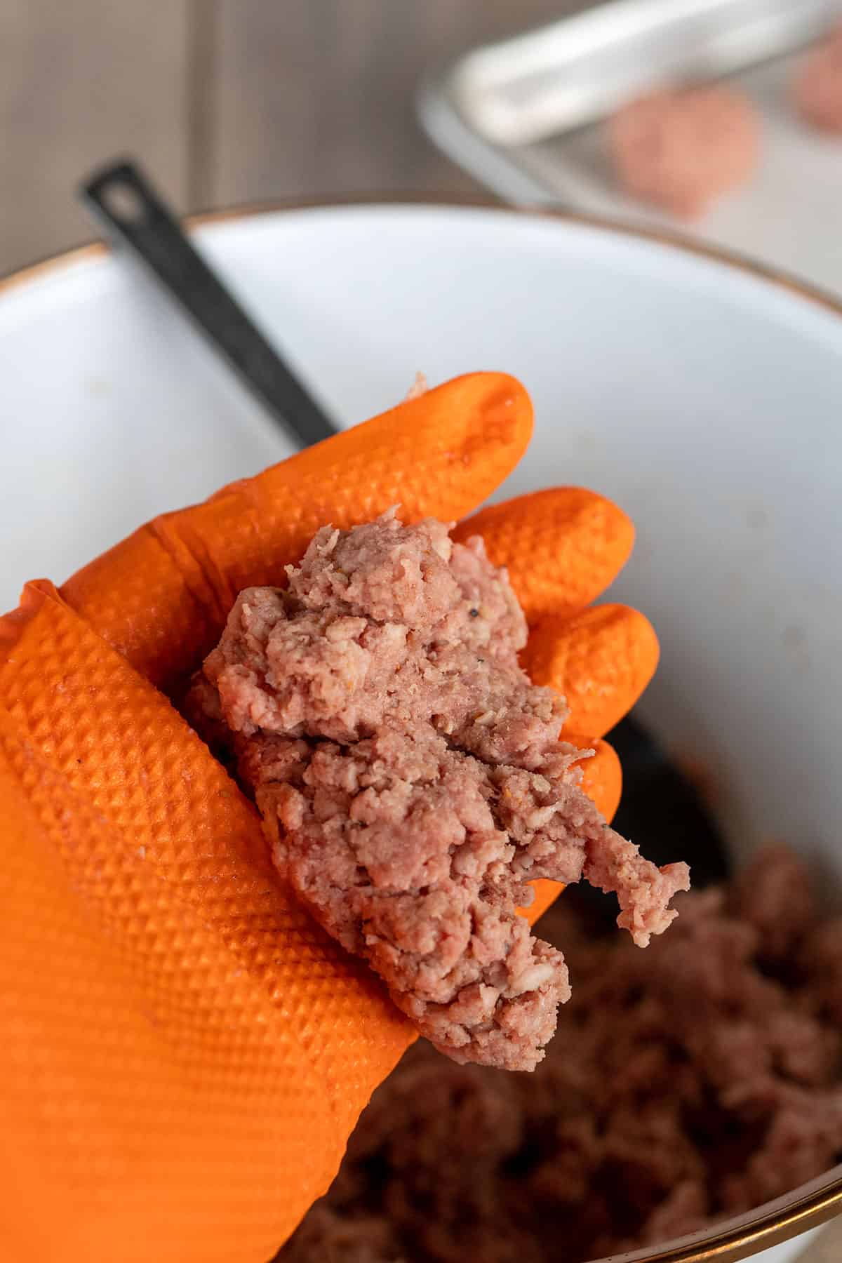 holding a handful of ground beef.