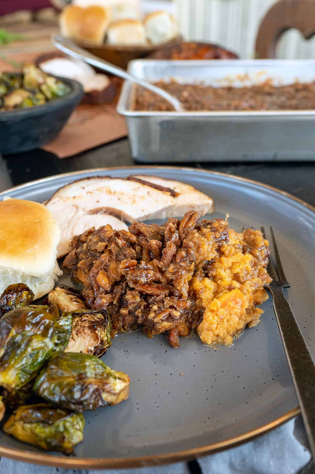 serving of sweet potato casserole on plate with turkey and brussels sprouts.