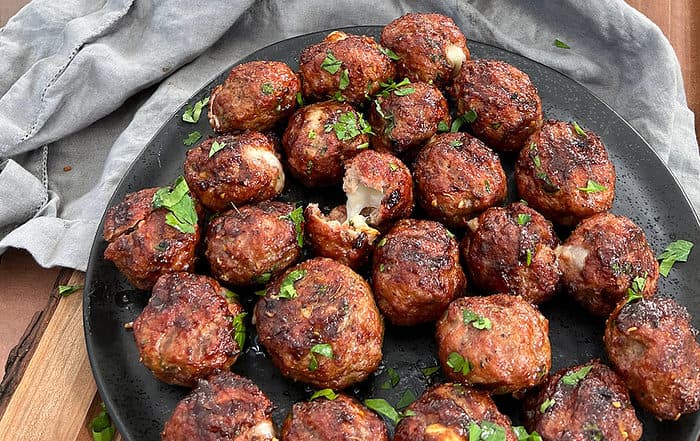 smoked cheese stuffed meatballs on a plate.