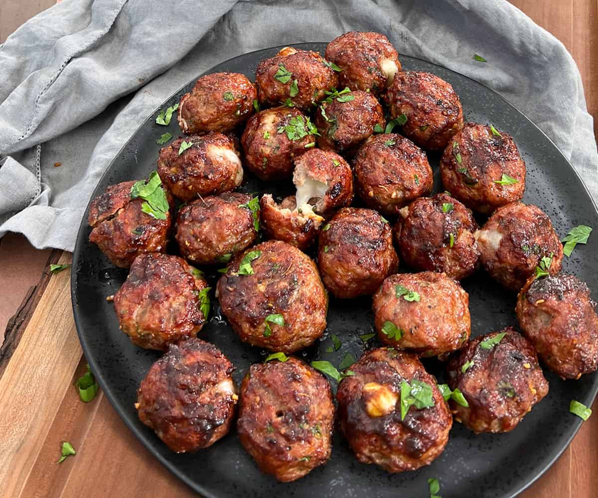 smoked cheese stuffed meatballs on a plate.
