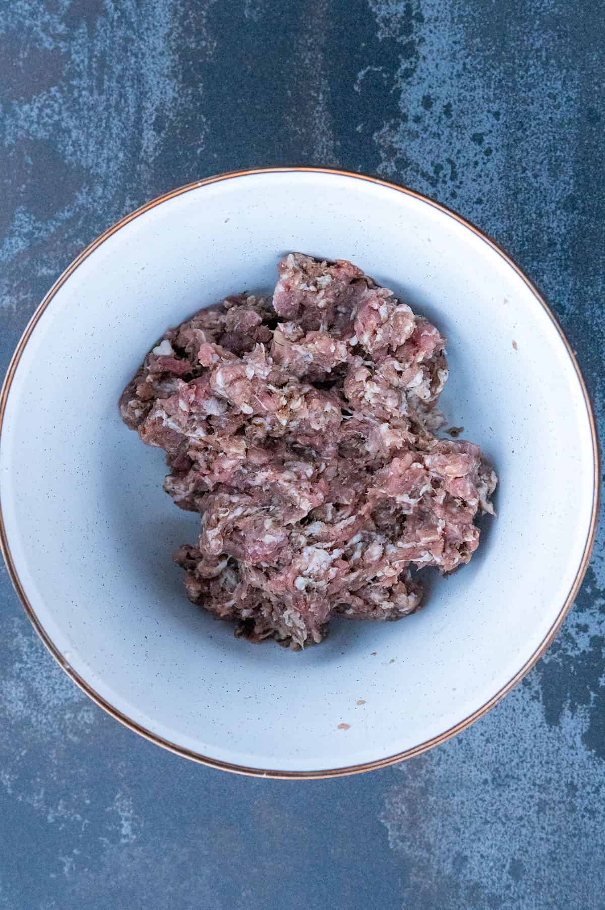 bowl of ground pork mixed with seasonings.