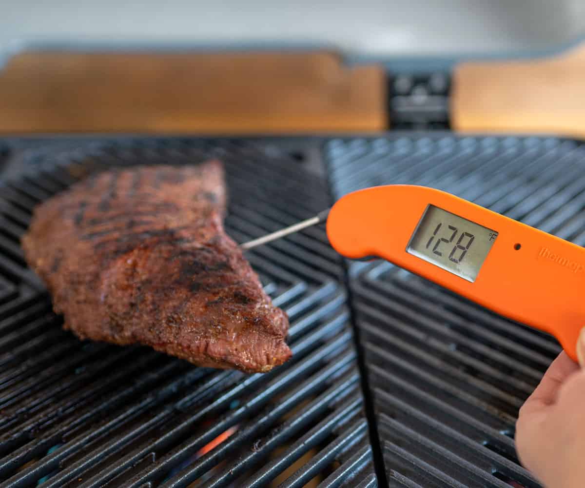 instant read meat thermometer showing tri tip at 128F degrees.