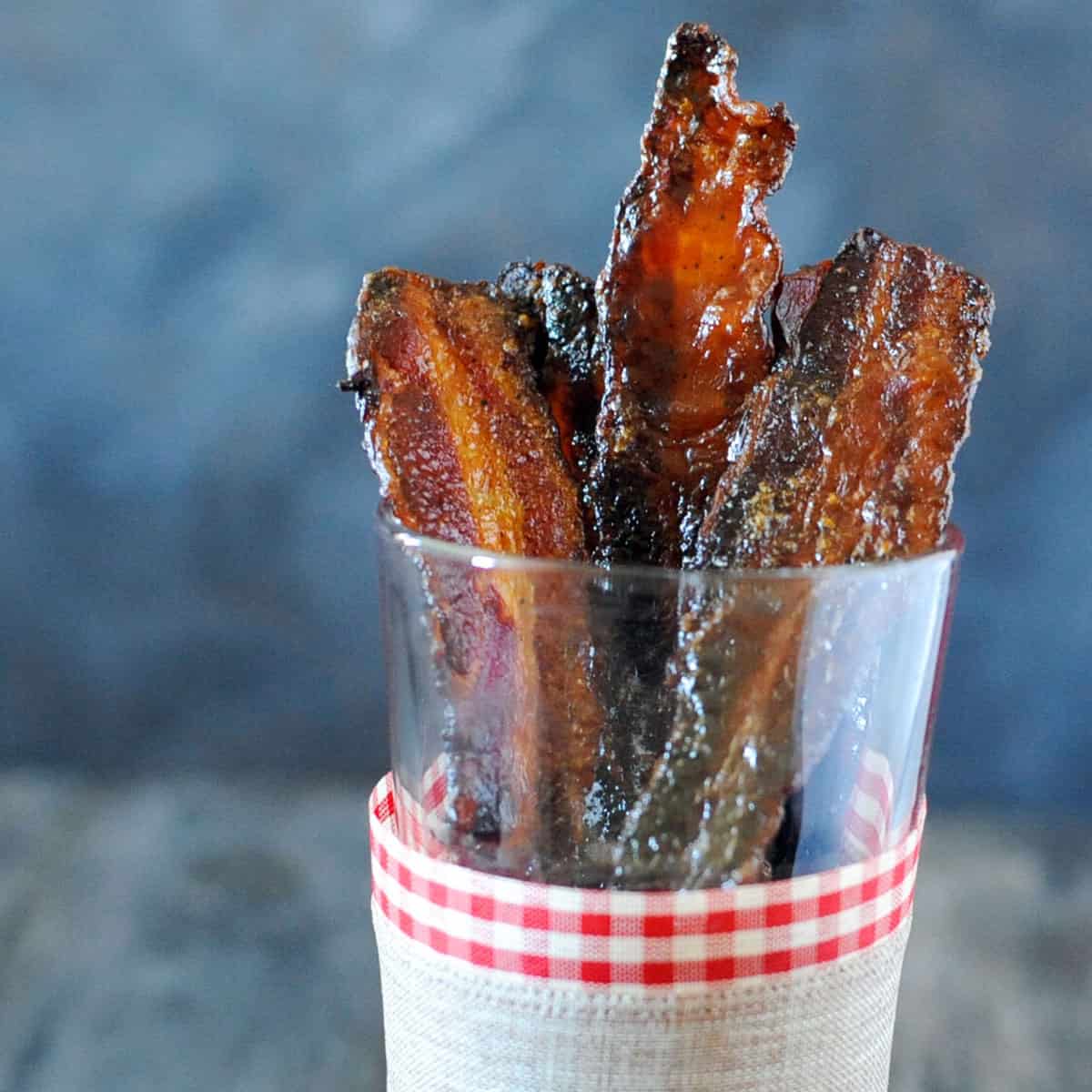 candied brown sugar bacon in glass.