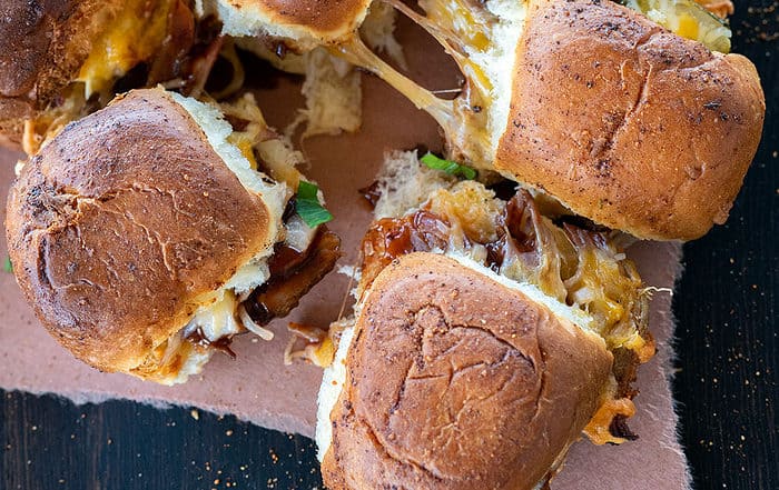 pulled pork sliders pulled apart with cheese pull.