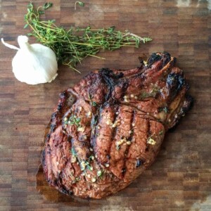 ribeye steak on wooden platter.