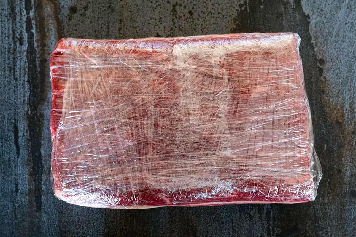 trimmed brisket flat wrapped in plastic.