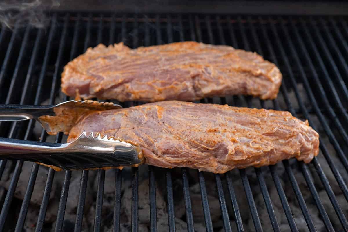 two pork tenderloins placed on grill.