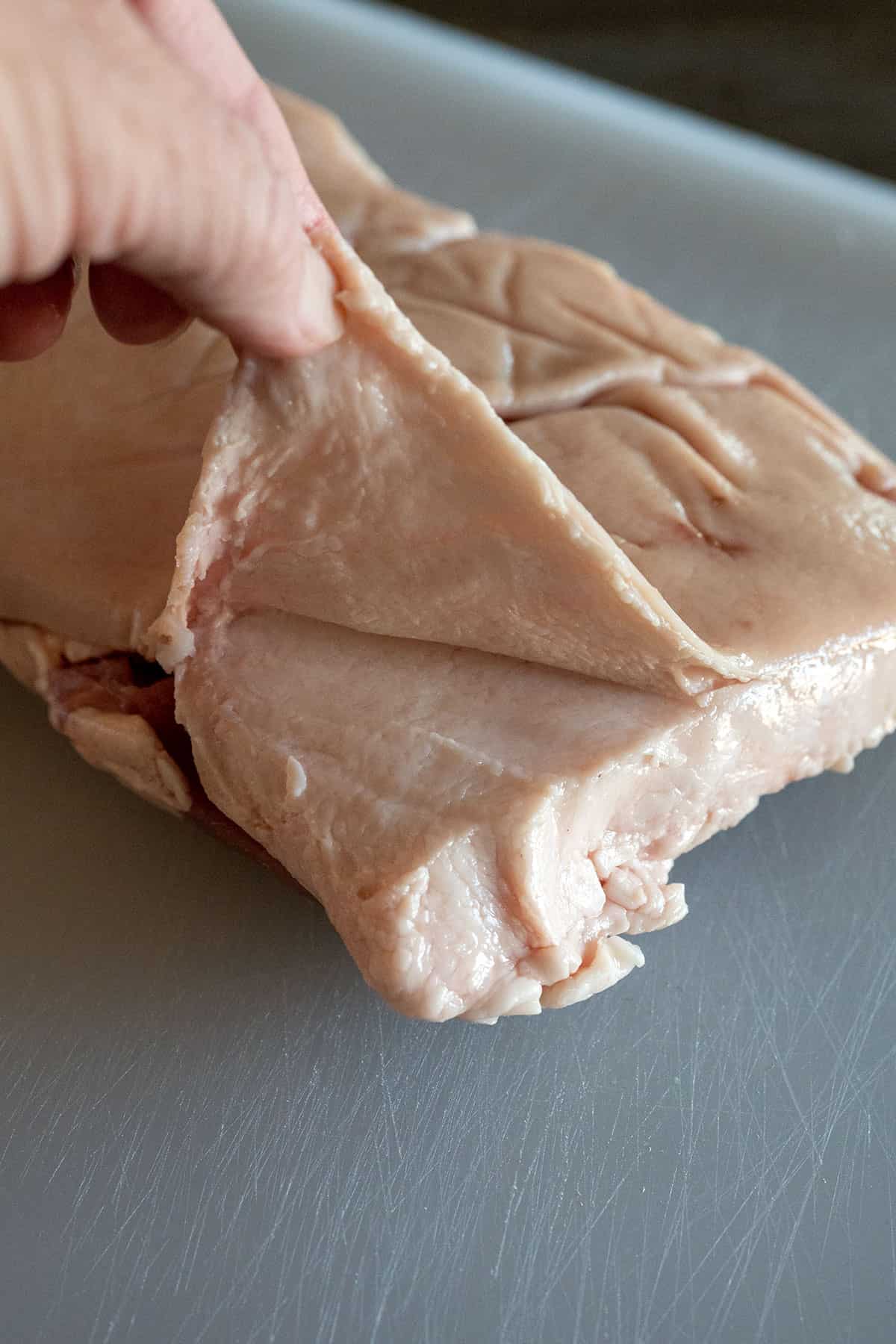 removing skin from pork belly.