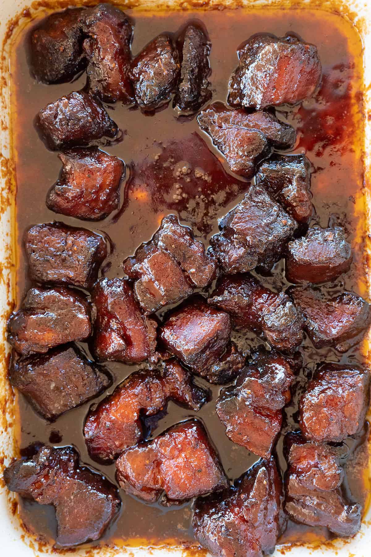smoked pork belly burnt ends in sauce.
