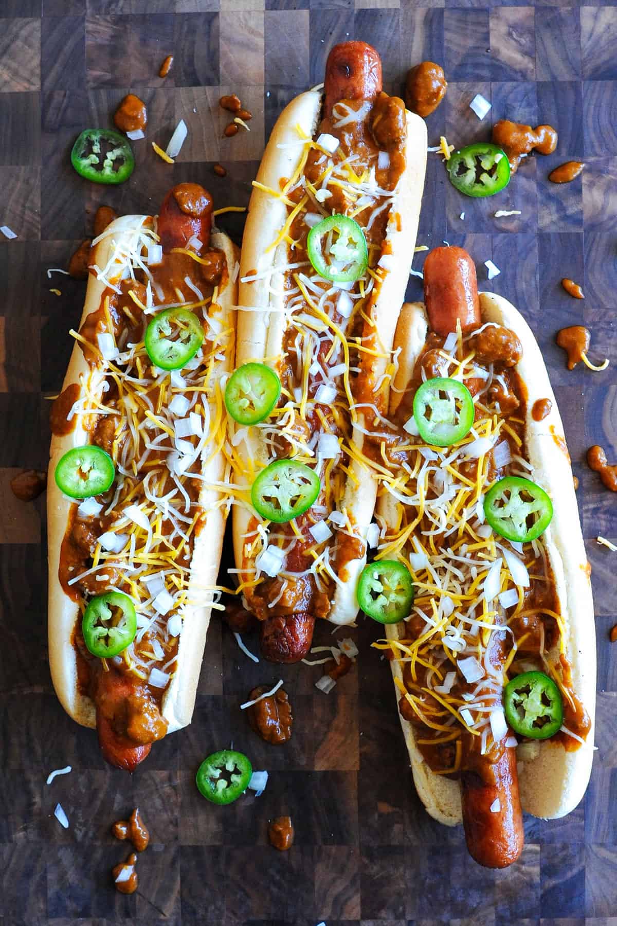 hot dogs topped with chili and jalapenos.
