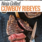 sliced cowboy ribeye steak on black platter.