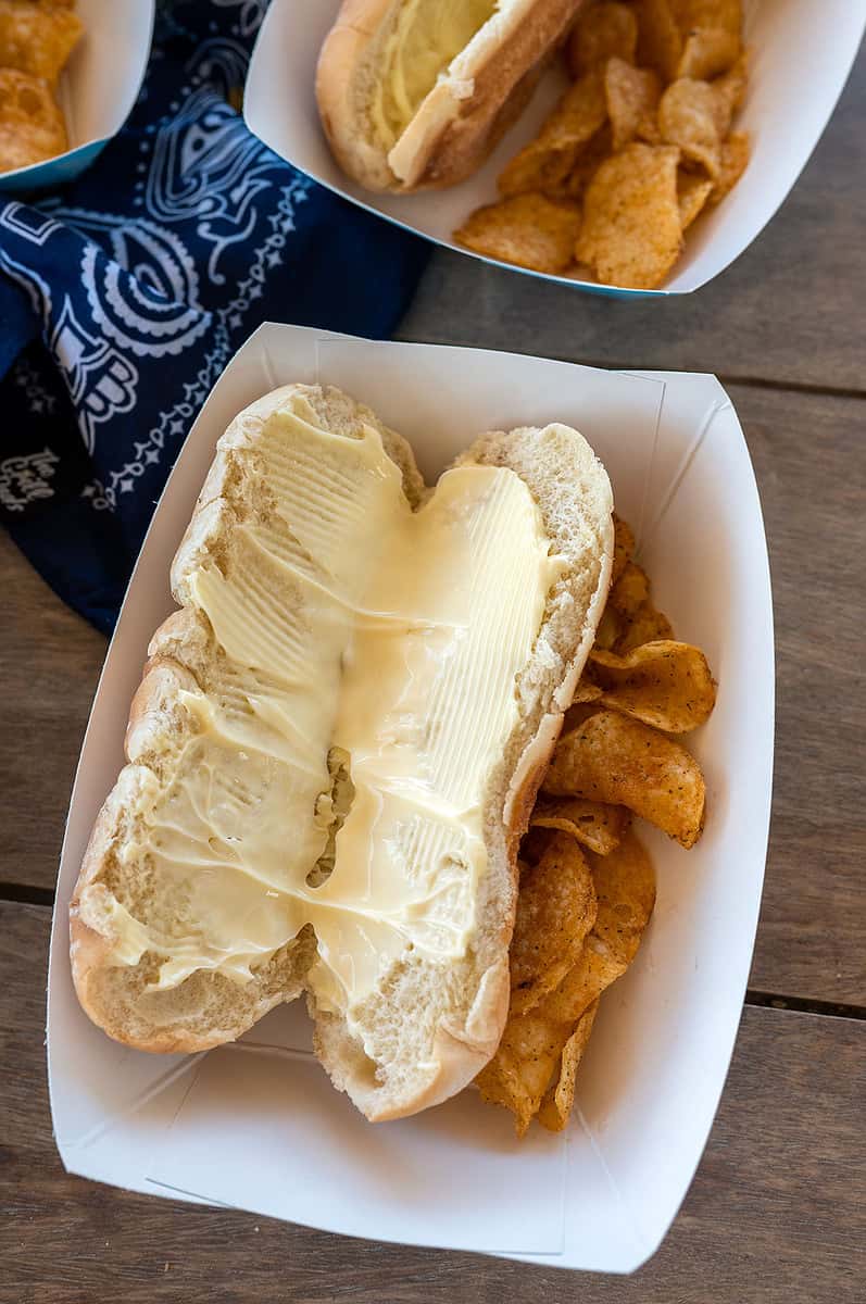 mayonnaise spread on a hot dog bun.