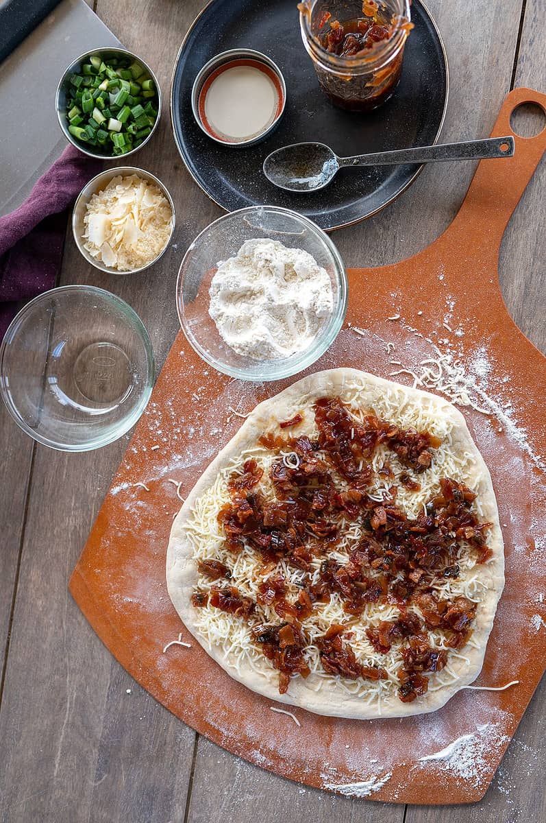 bacon jam pizza topped with bacon jam.