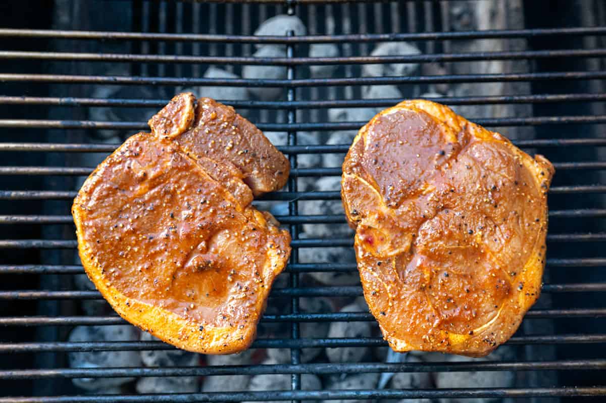 seasoned pork chops on grill.