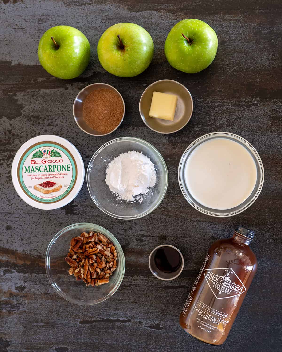 caramel apple cheesecake stack ingredients: apples, cinnamon sugar, butter, mascarpone, powdered sugar, cream, pecans, vanilla, apple cider syrup.