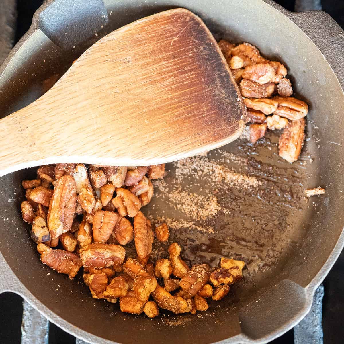Cinnamon sugar starting to melt in pan with pecans.