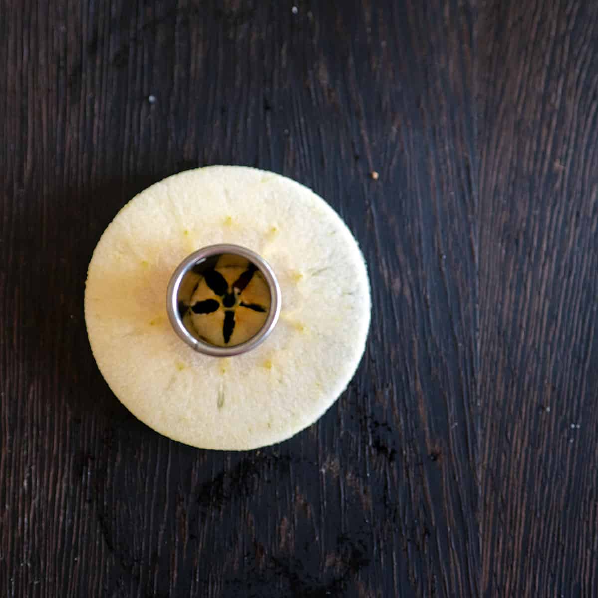 Using 1-inch circle cutter to remove core from apple slice.