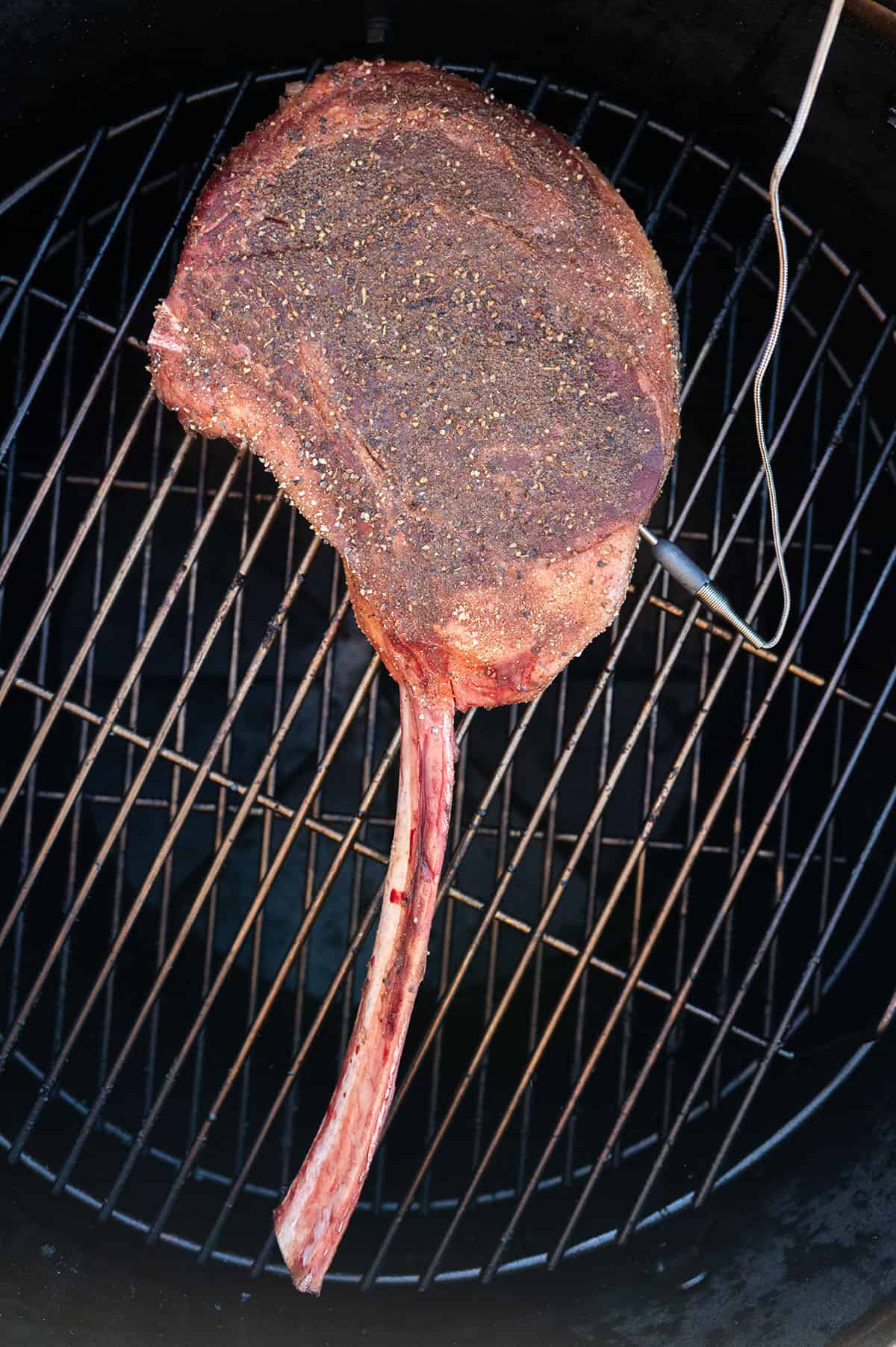 Seasoned tomahawk steak on grill.