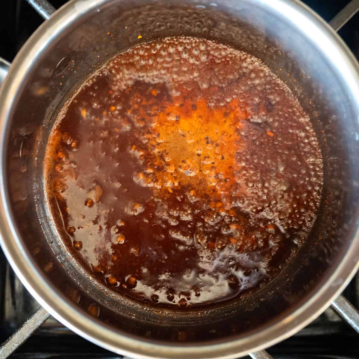 vinegar and pork rub simmering in pot.