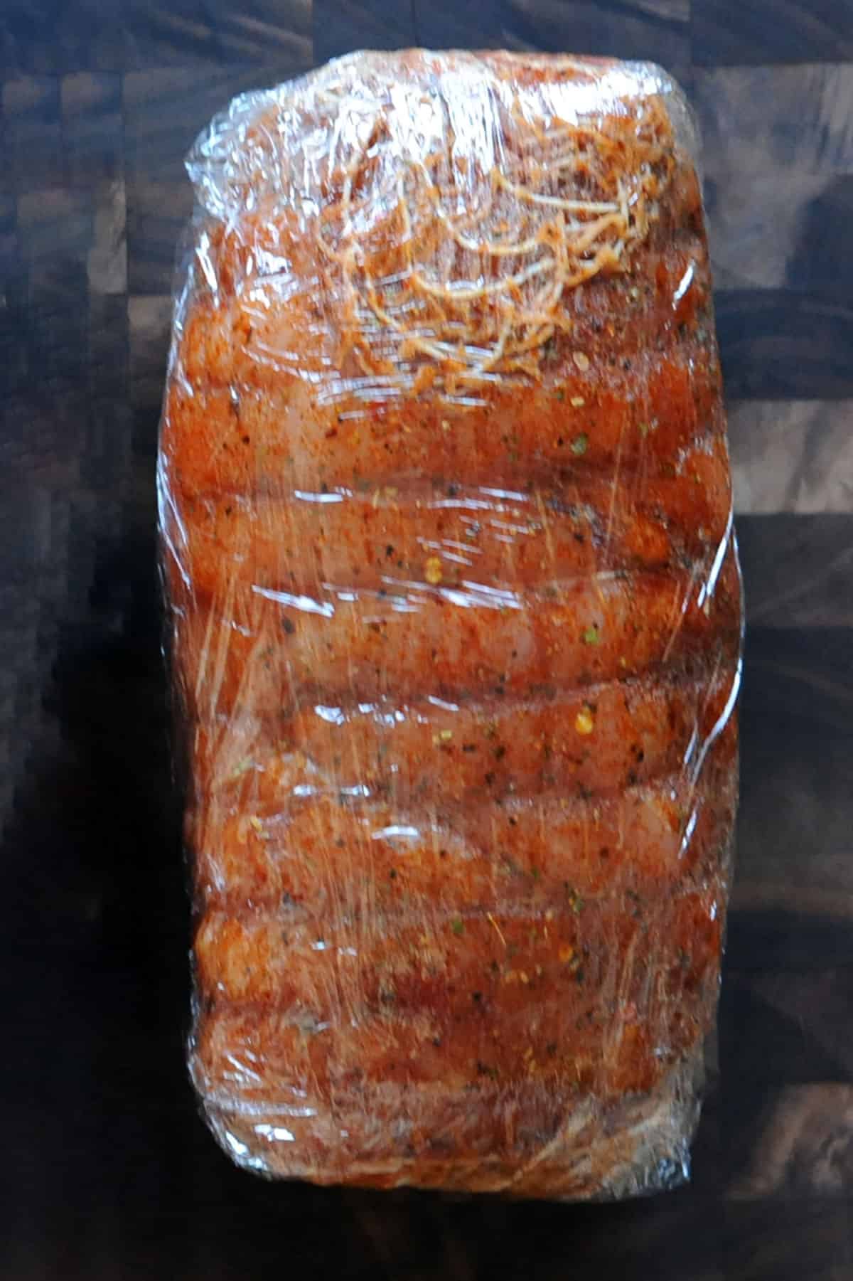 Turkey roast seasoned and wrapped in plastic.