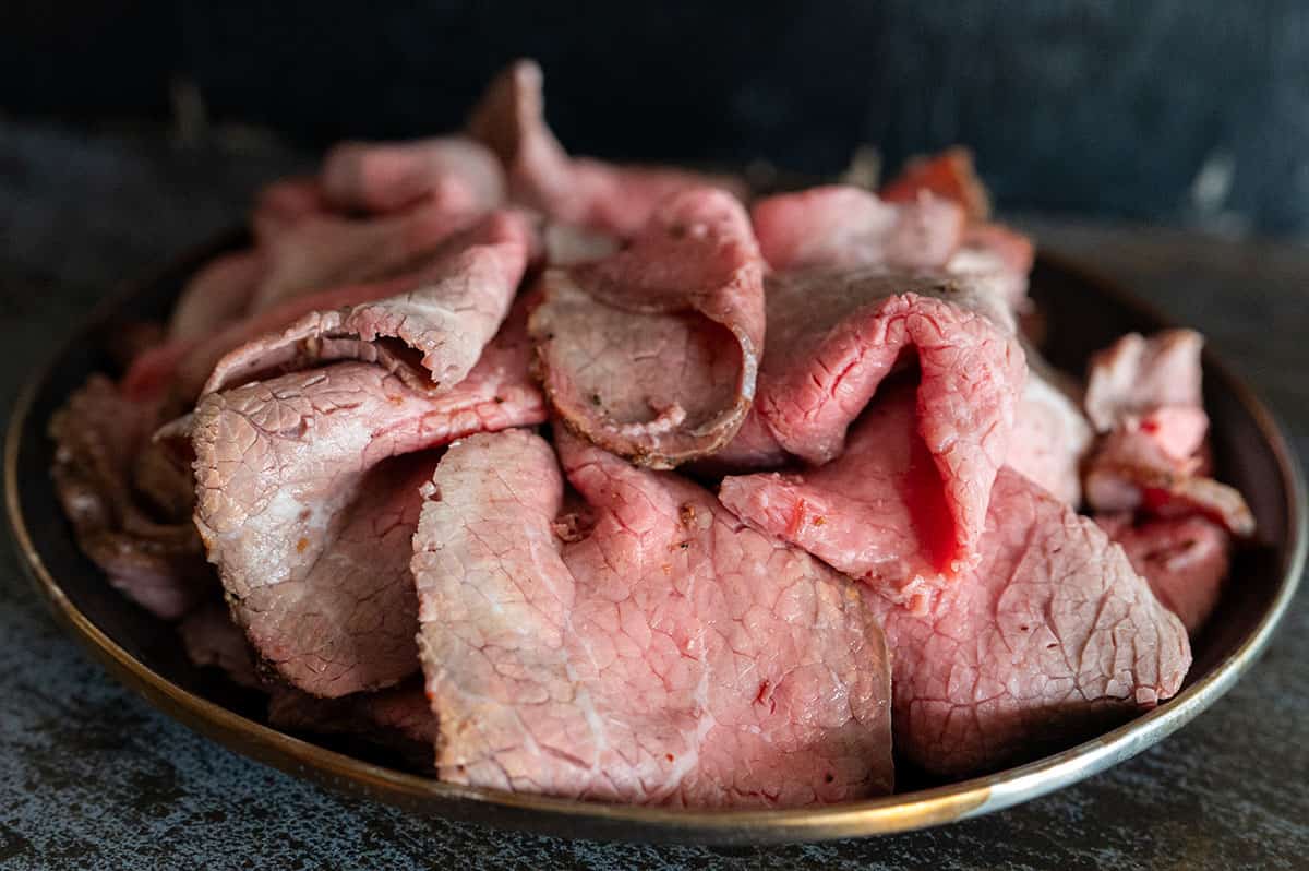 Thinly sliced roast beef on a plate.