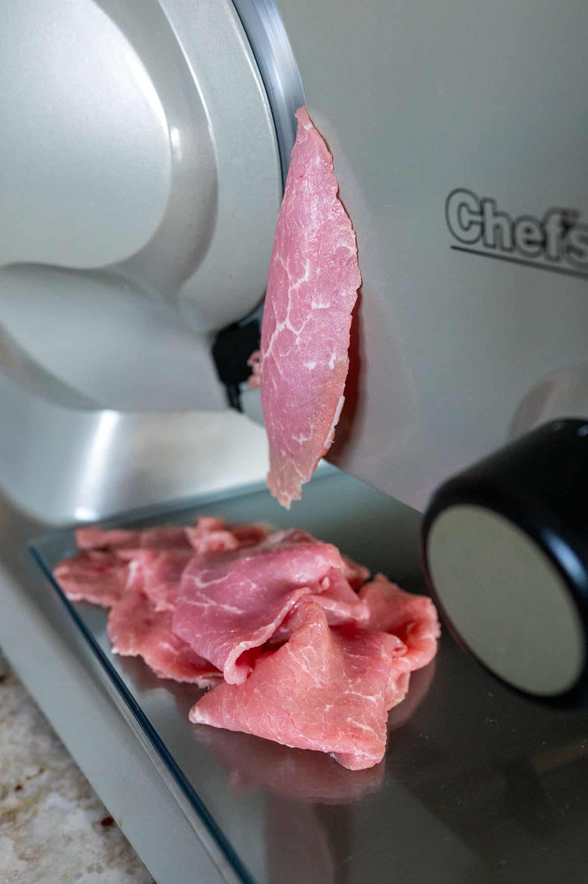 Eye of round sliced into thin strips with meat slicer.