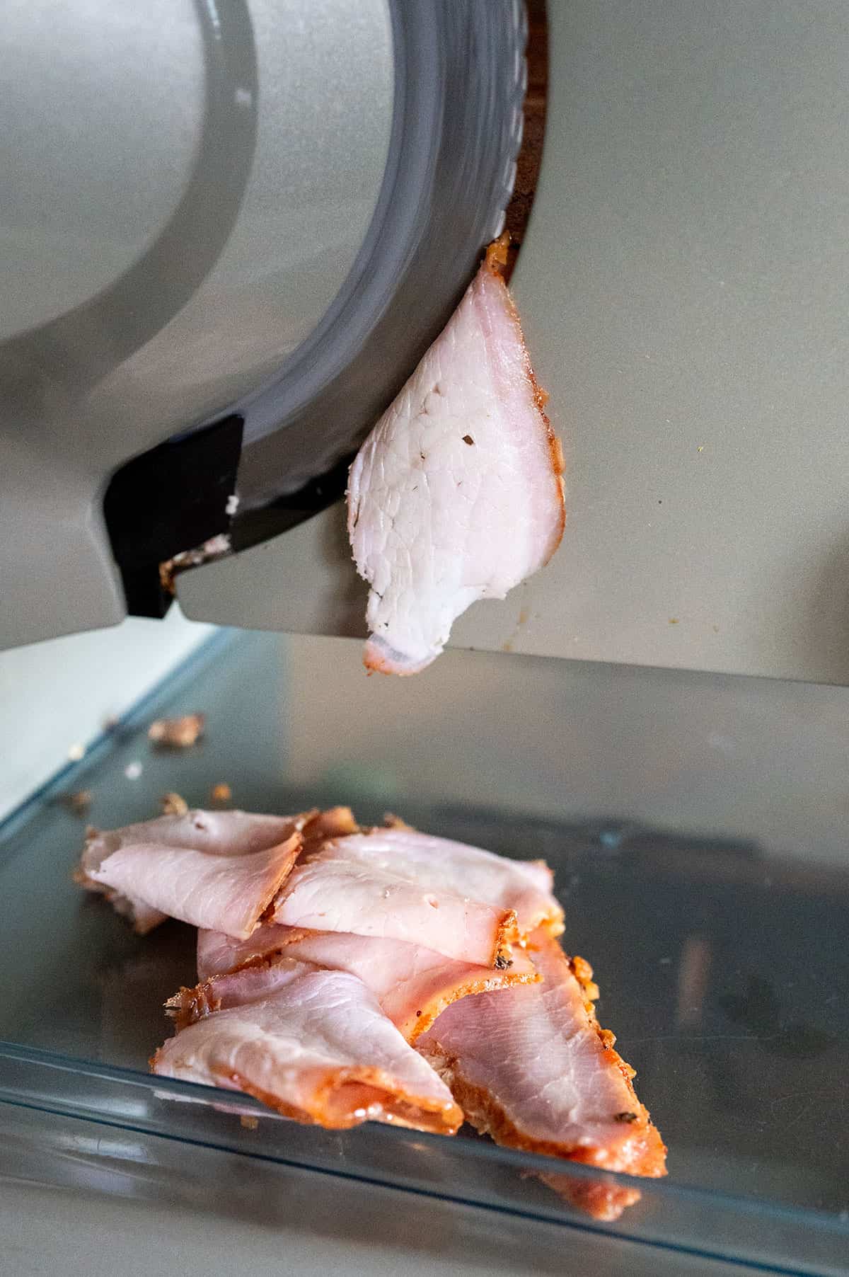 Thinly slicing a smoked pork loin to make lunch meat.